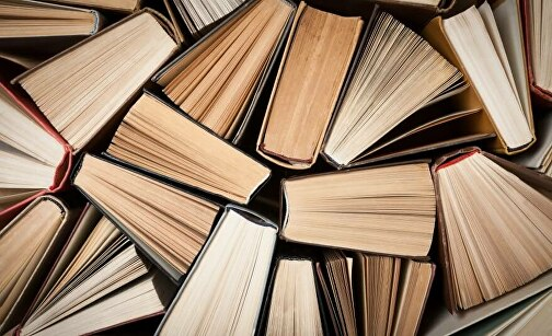 Книжкова атмосфера: дерев'яний стіл з блокнотом, фінансовими аналітичними матеріалами та аксесуарами для бізнесу.