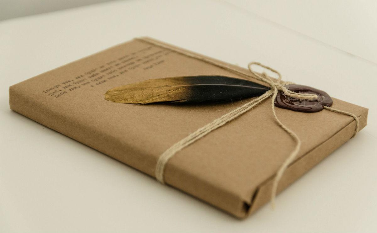 Жінка пакує книгу у подарунковий папір